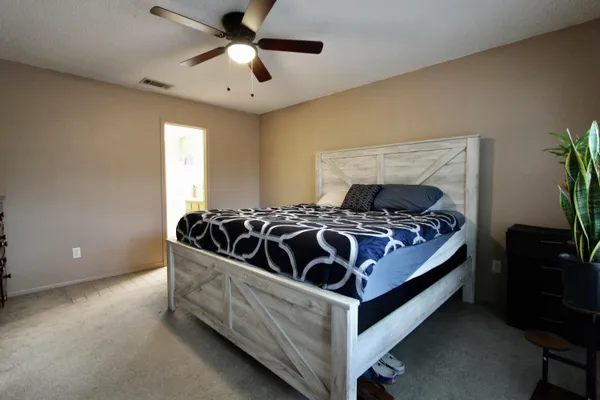 a bed sitting in a bedroom next to a window with a chandelier