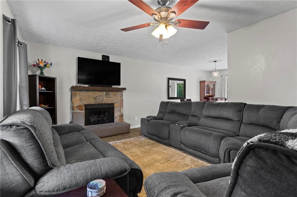 4593 Mars Court Acworth, GA 30101 - Photo 4 of 19 a living room with furniture a flat screen tv and a fireplace