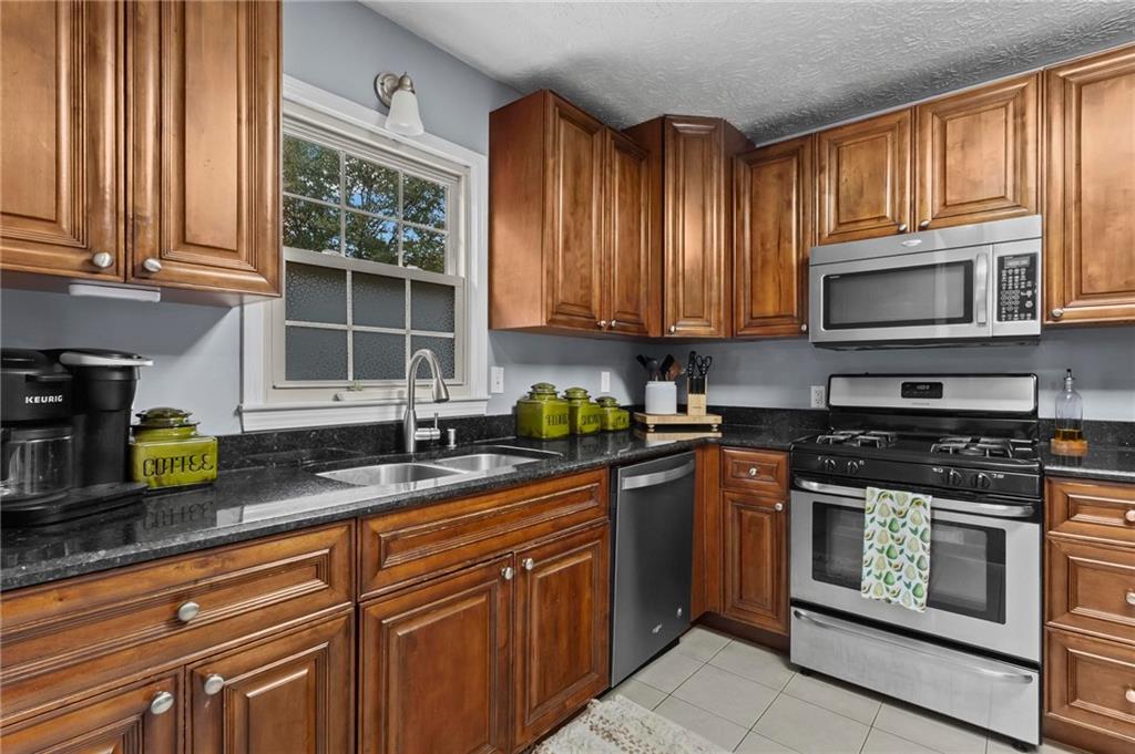 4593 Mars Court Acworth, GA 30101 - Photo 8 of 19 a kitchen with stainless steel appliances granite countertop a stove a sink and a microwave