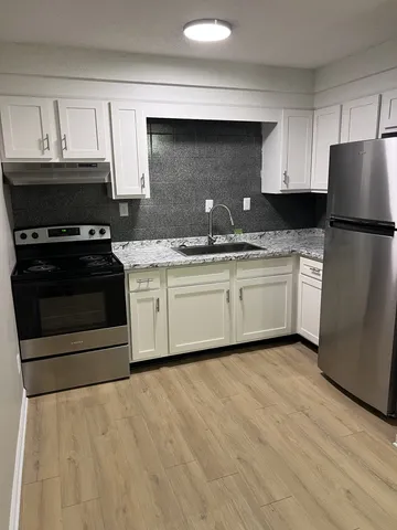 a kitchen with stainless steel appliances granite countertop a stove a sink and a refrigerator