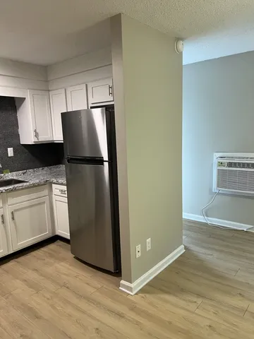a kitchen with a refrigerator sink and cabinets