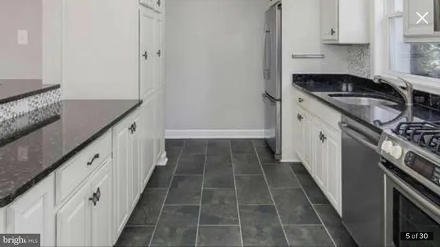 a kitchen with granite countertop a sink stove and cabinets