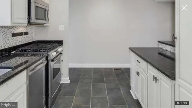 a kitchen with granite countertop a sink and cabinets