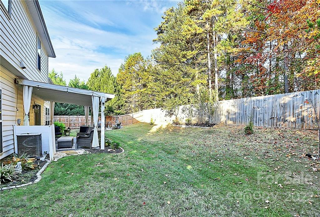 12403 Old Timber Road Charlotte, NC 28269 - Photo 27 of 33 a view of a backyard with table and chairs and wooden fence