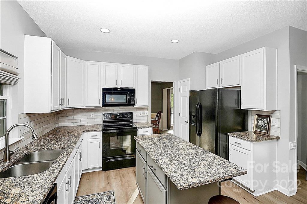 12403 Old Timber Road Charlotte, NC 28269 - Photo 7 of 33 a kitchen with granite countertop a refrigerator stove and sink