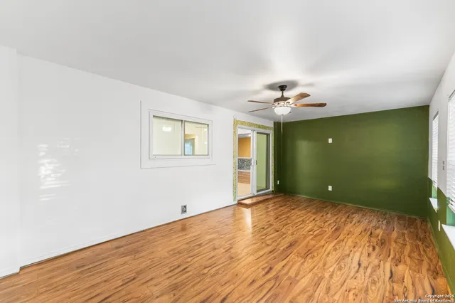a view of a livingroom with wooden floor and a ceiling fan