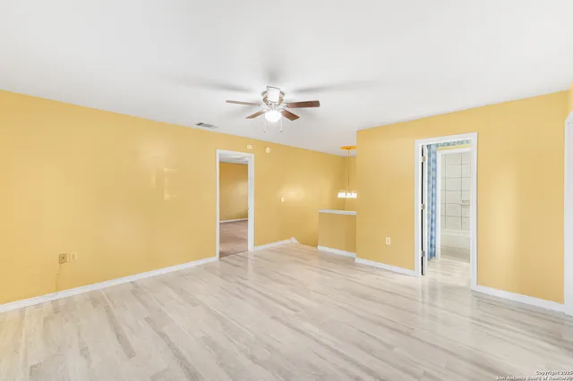 a view of a big room with wooden floor and a ceiling fan