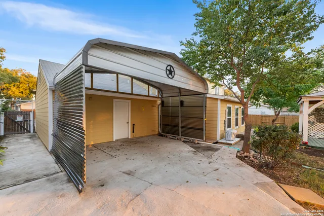 a view of a house with a small yard and wooden fence