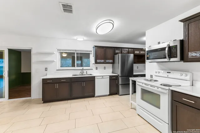 a kitchen with stainless steel appliances granite countertop a stove cabinets and refrigerator