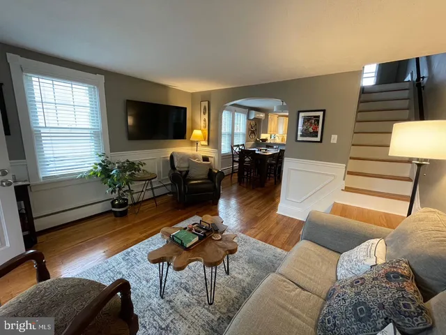 a living room with furniture a flat screen tv and a window