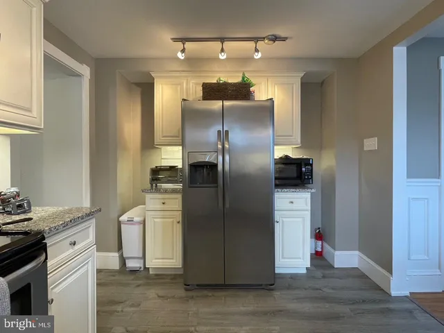 a kitchen with stainless steel appliances granite countertop a refrigerator and a stove