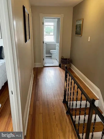 a view of a hallway with wooden floor and stairs