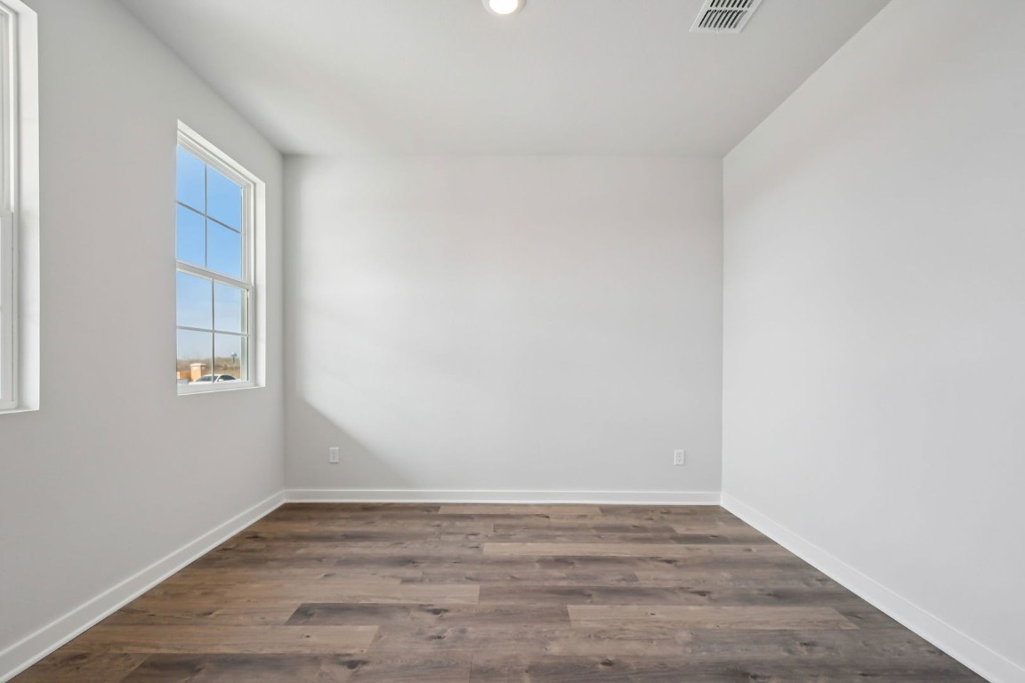 13419 Derby Ride Drive Buda, TX 78610 - Photo 20 of 29 a view of an empty room with wooden floor and a window