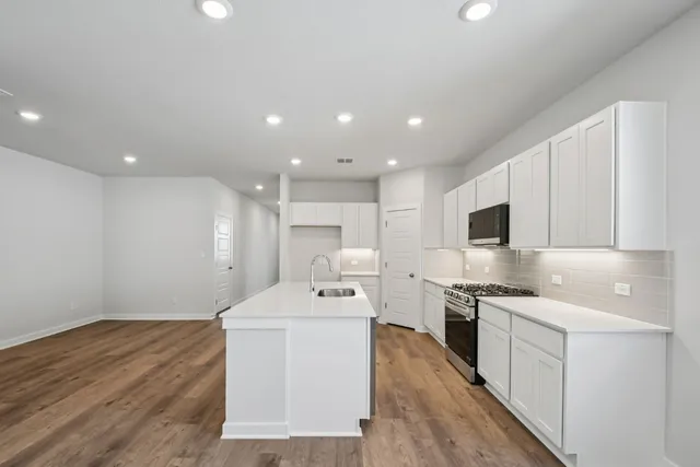 a kitchen with a sink stainless steel appliances and white cabinets