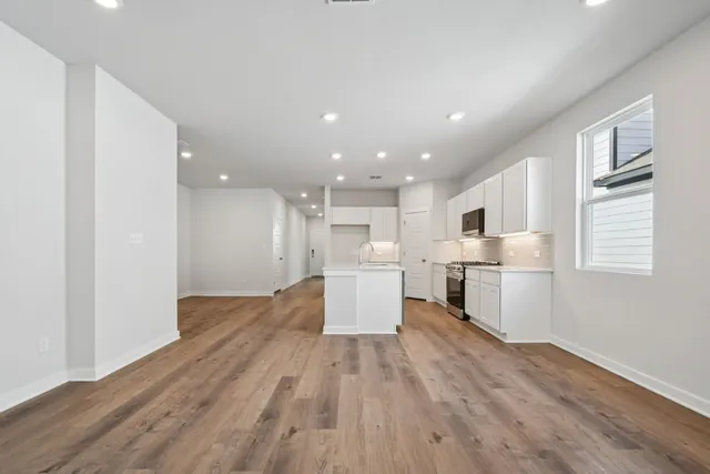 a view of kitchen with wooden floor and electronic appliances