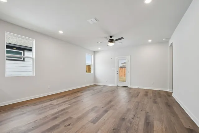 a view of an empty room with wooden floor