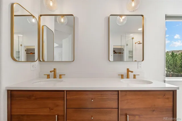 a bathroom with a double vanity sink mirror and shower