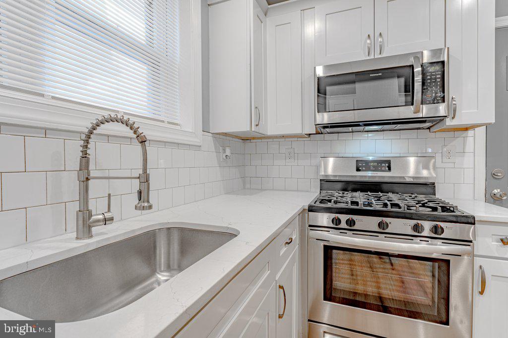 215 North Fairview Street Riverside, NJ 08075 - Photo 12 of 25 a kitchen with stainless steel appliances granite countertop a sink stove and microwave