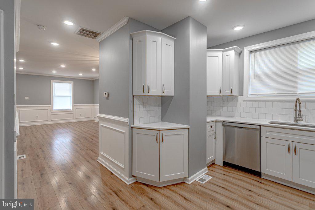 215 North Fairview Street Riverside, NJ 08075 - Photo 9 of 25 a kitchen with stainless steel appliances granite countertop a stove a sink and white cabinets with wooden floor