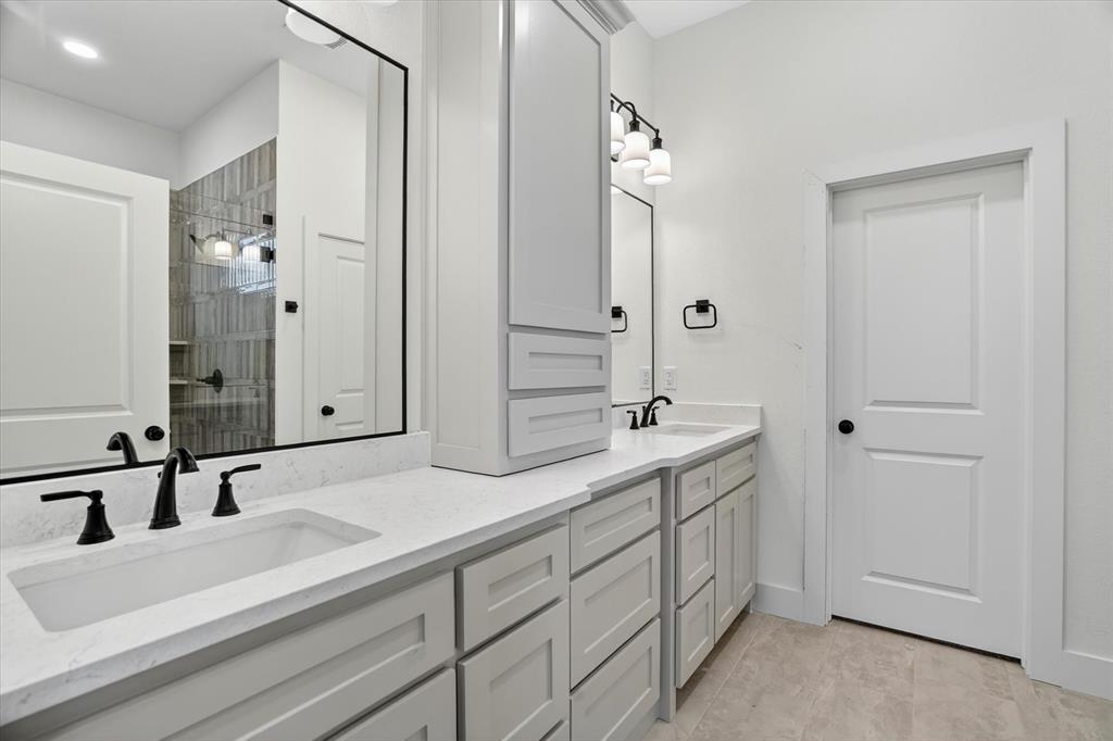 225 Kilkenny Road Poolville, TX 76487 - Photo 18 of 36 Dual vanity featuring light gray cabinetry, white countertops, undermount sinks, and matte black fixtures