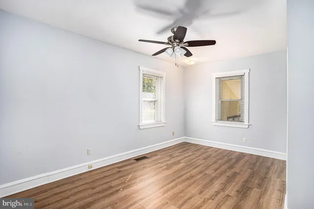 a view of a room with wooden floor and windows