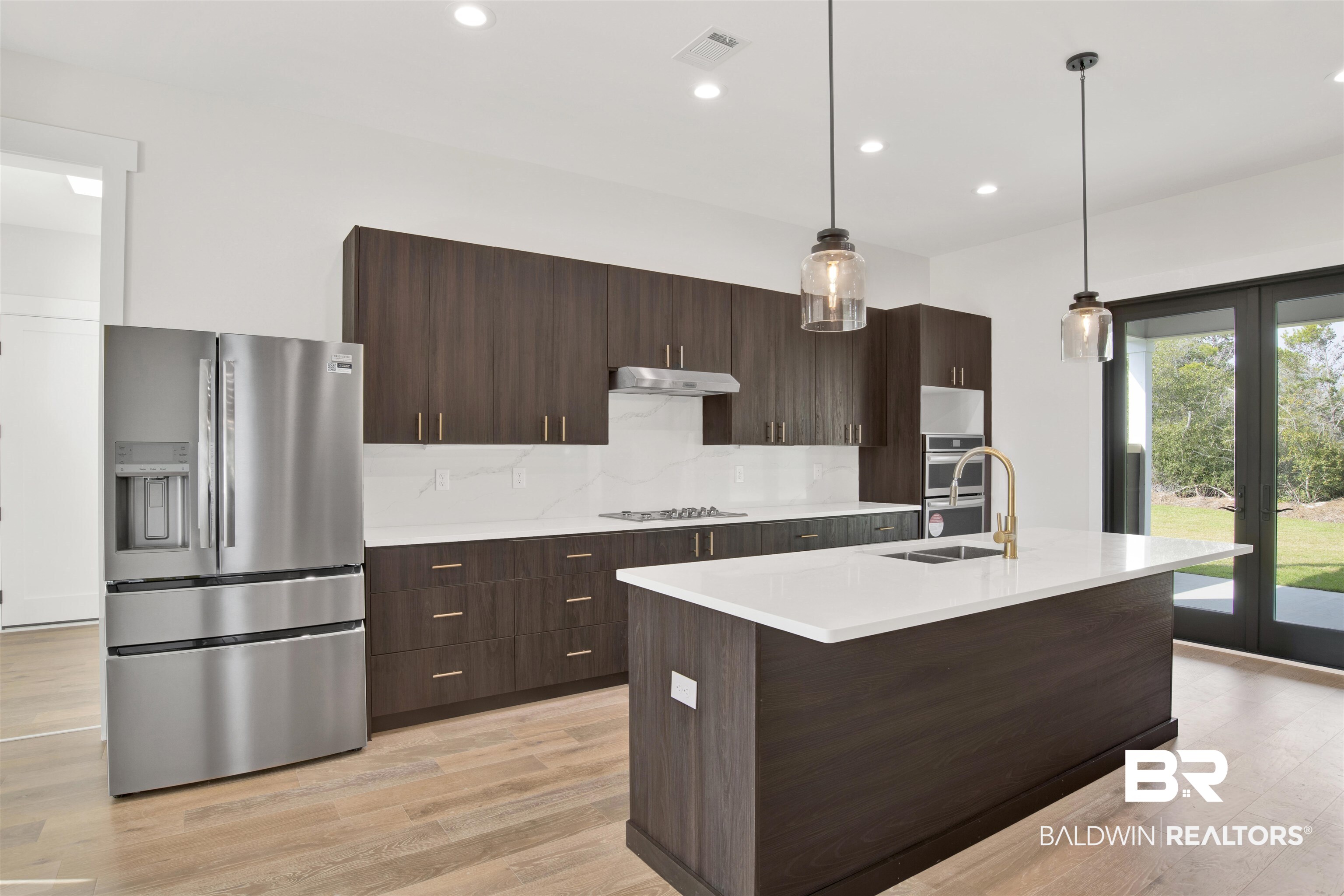 31545 River Road Orange Beach, AL 36561 - Photo 2 of 59 Kitchen with appliances with stainless steel finishes, decorative light fixtures, engineered wood flooring and French doors
