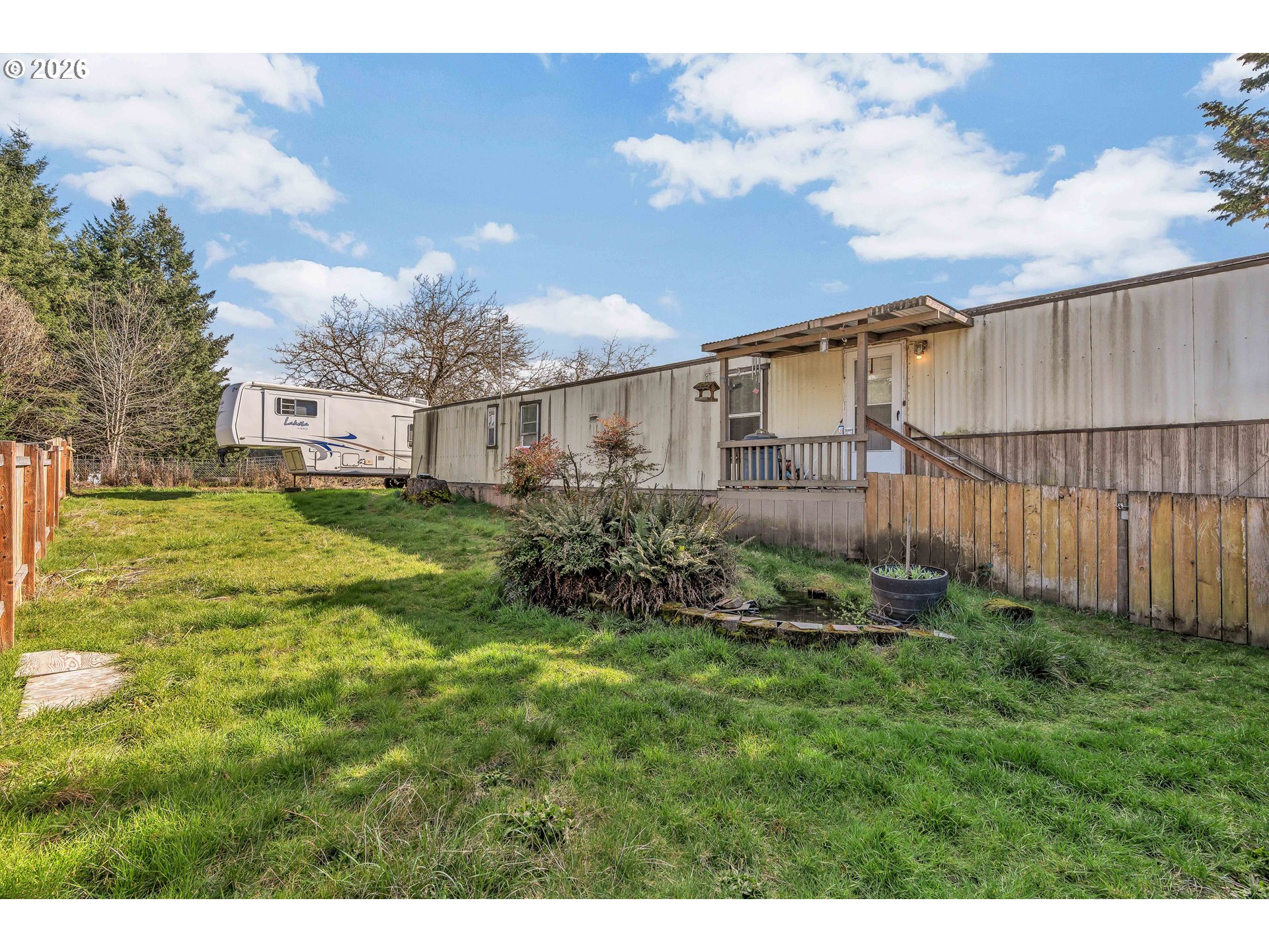 10038 South New Era Road, Unit 25 Canby, OR 97013 - Photo 33 of 39 a view of a garden with a building in the background