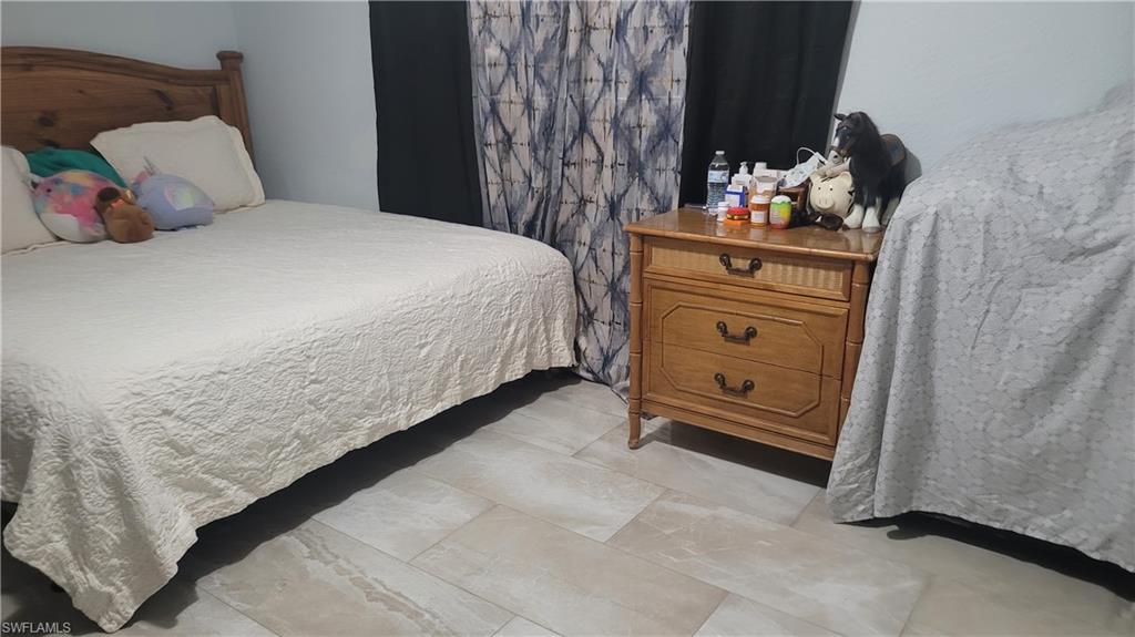 2172 45th Street Southwest Naples, FL 34116 - Photo 16 of 26 a bedroom with a bed and a dresser