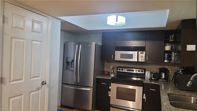 a kitchen with stainless steel appliances granite countertop a refrigerator and a stove top oven