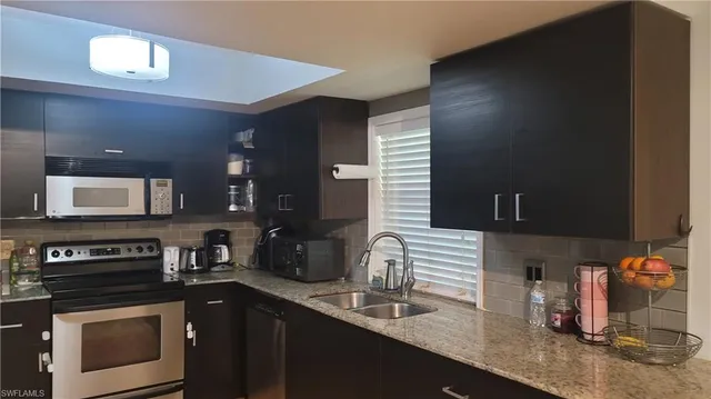 a kitchen with stainless steel appliances granite countertop a sink and a stove