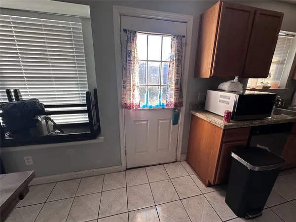 a view of a kitchen with fridge and wooden floor