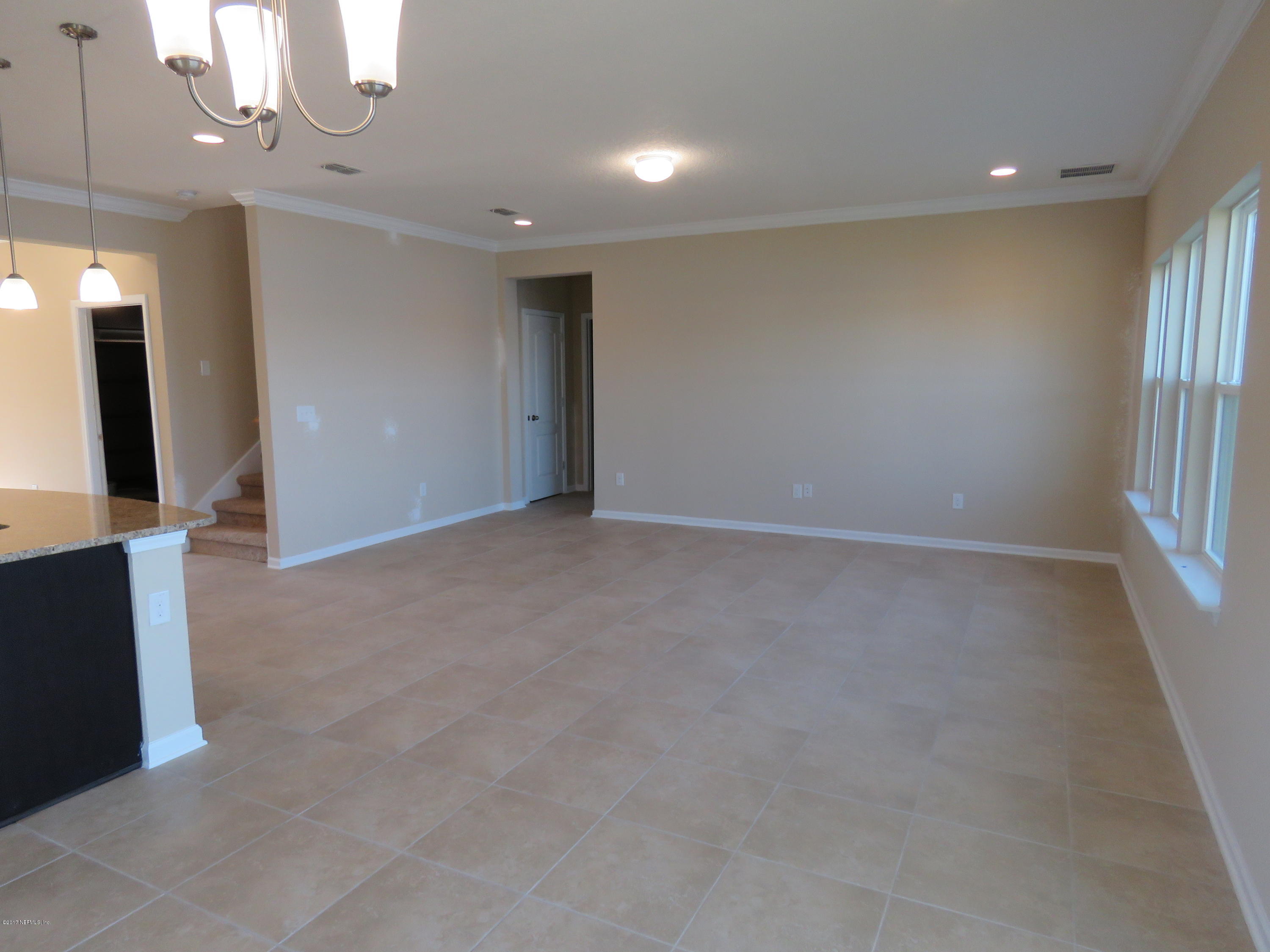 516 Deer Crossing Road St. Augustine, FL 32086 - Photo 21 of 43 an empty room with a chandelier fan and windows