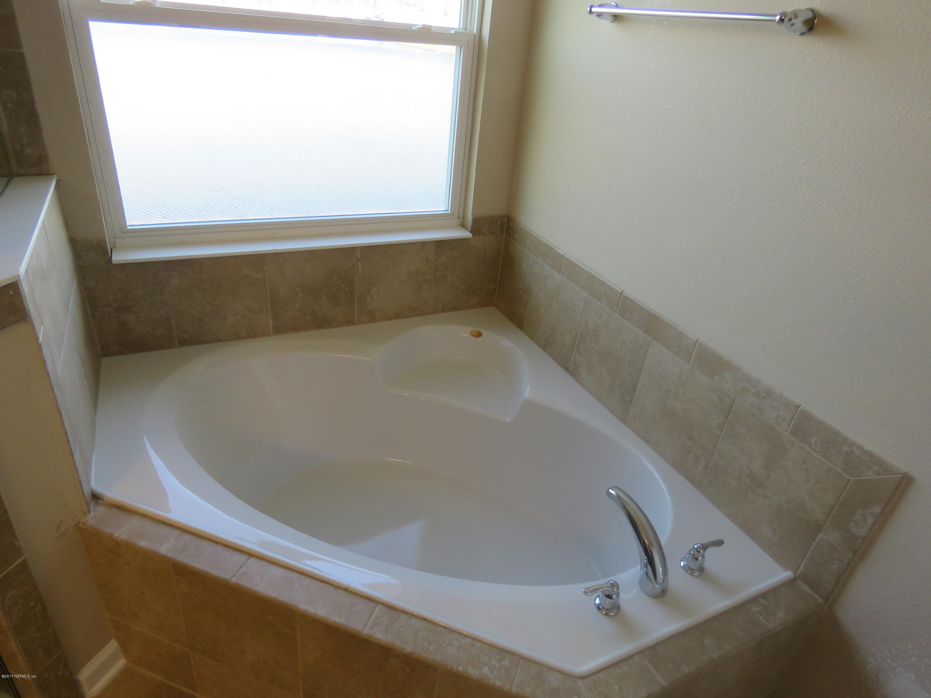 516 Deer Crossing Road St. Augustine, FL 32086 - Photo 41 of 43 a bath tub sitting in a bathroom next to a window
