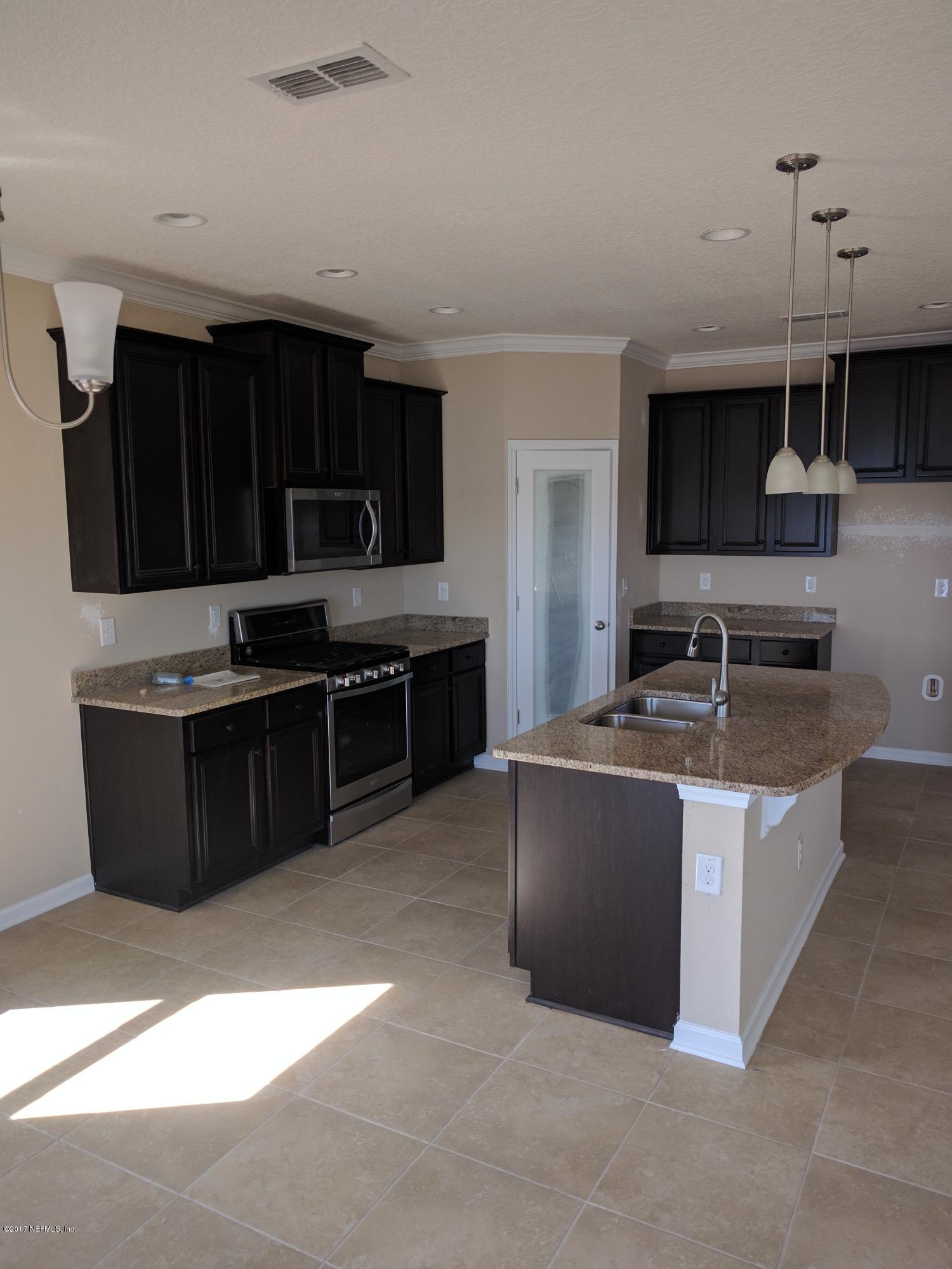 516 Deer Crossing Road St. Augustine, FL 32086 - Photo 5 of 43 a kitchen with stainless steel appliances granite countertop a stove a sink and a microwave