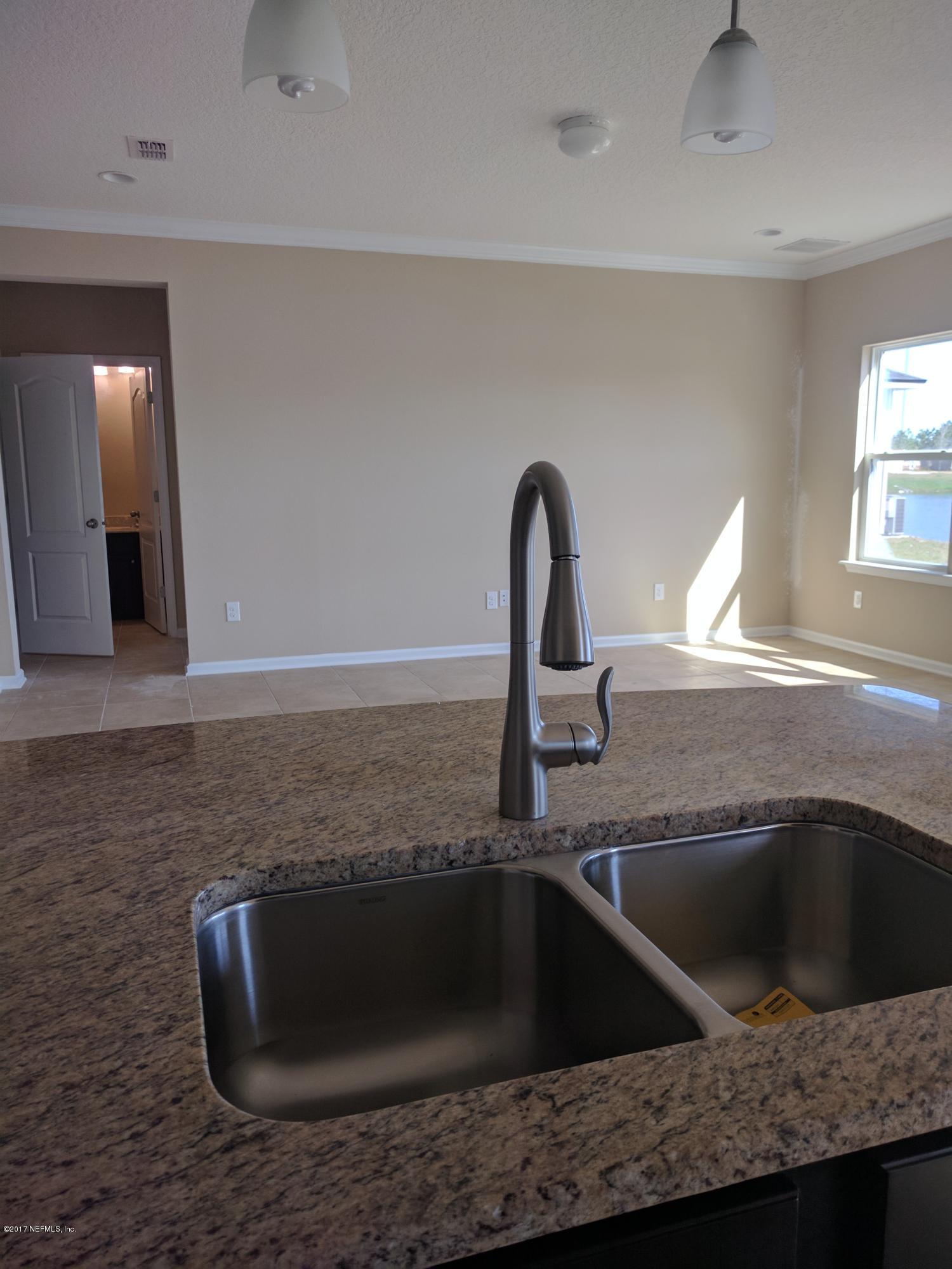516 Deer Crossing Road St. Augustine, FL 32086 - Photo 6 of 43 a kitchen with granite countertop a sink and a wooden floor