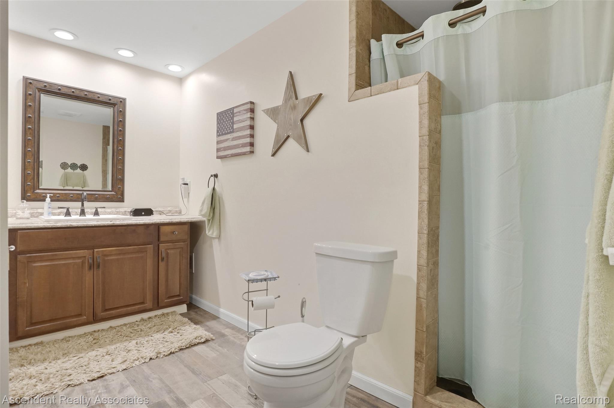 6157 Blue Beech Court Rochester, MI 48306 - Photo 14 of 30 In Suite 1st Floor master bathroom. Wood-finish flooring, recessed lighting, and a vanity with a rectangular sink and dark cabinetry
