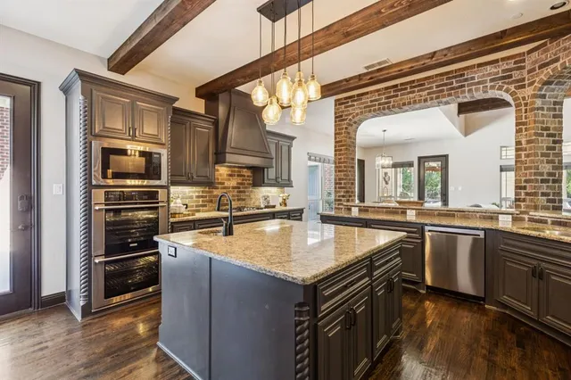 a kitchen with stainless steel appliances granite countertop a sink and stove top oven
