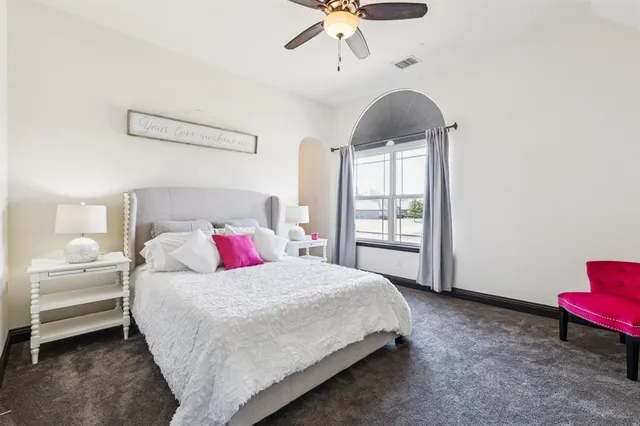 a bedroom with a bed chandelier and a window