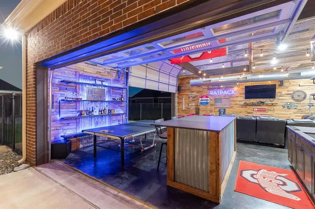 a living room with stainless steel appliances kitchen island granite countertop a stove and a wooden floor