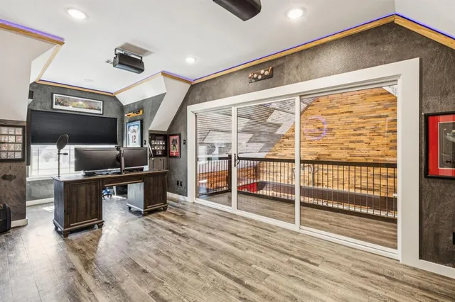 a kitchen with stainless steel appliances wooden floor and a refrigerator