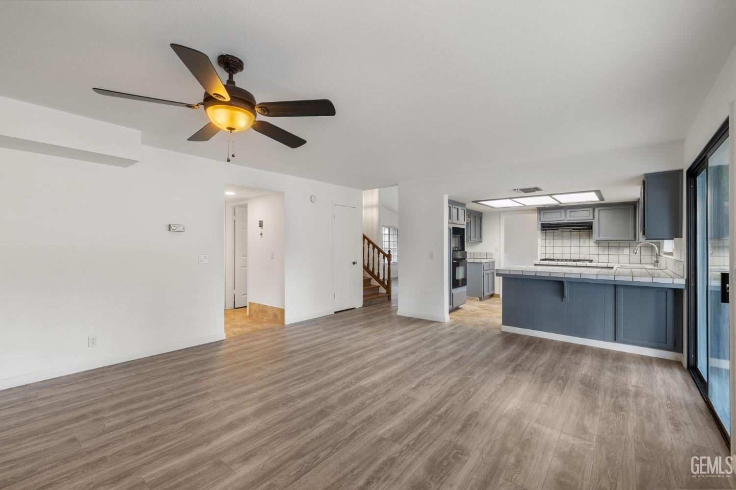 Undisclosed Address Ridgecrest, CA 93555 - Photo 15 of 34 a view of an empty room and kitchen with wooden floor