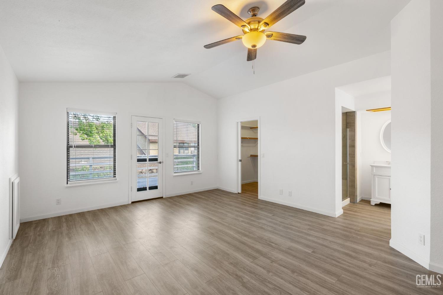 Undisclosed Address Ridgecrest, CA 93555 - Photo 16 of 34 an empty room with wooden floor chandelier fan and windows