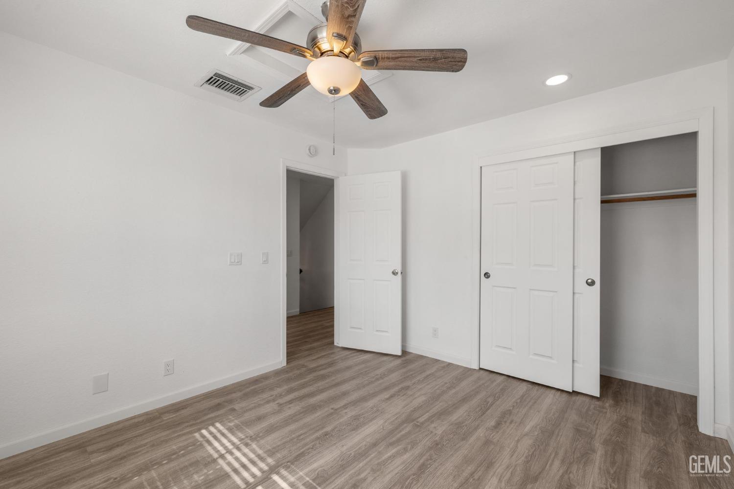 Undisclosed Address Ridgecrest, CA 93555 - Photo 23 of 34 an empty room with wooden floor ceiling fan and windows