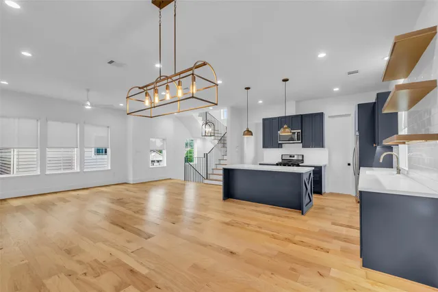 a large kitchen with stainless steel appliances kitchen island granite countertop a large counter top cabinets and appliances