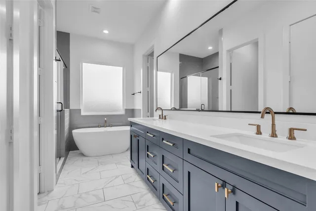 a spacious bathroom with a double vanity sink mirror and bathtub