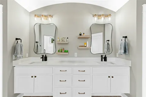 a bathroom with double vanity sinks and a mirror