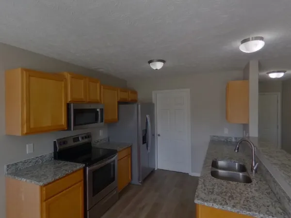 a kitchen filled with stainless steel appliances granite countertop a sink stove and refrigerator