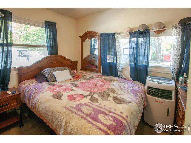 a bedroom with a bed and a large window