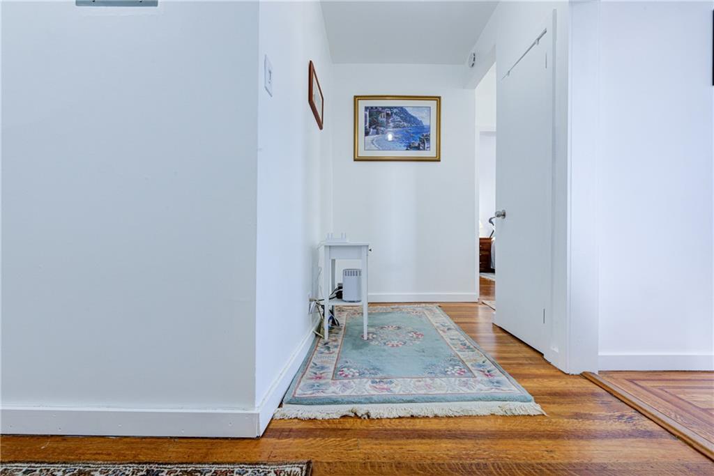 255 79th Street, Unit E11 Brooklyn, NY 11209 - Photo 15 of 34 a view of a hallway with wooden floor and a potted plant