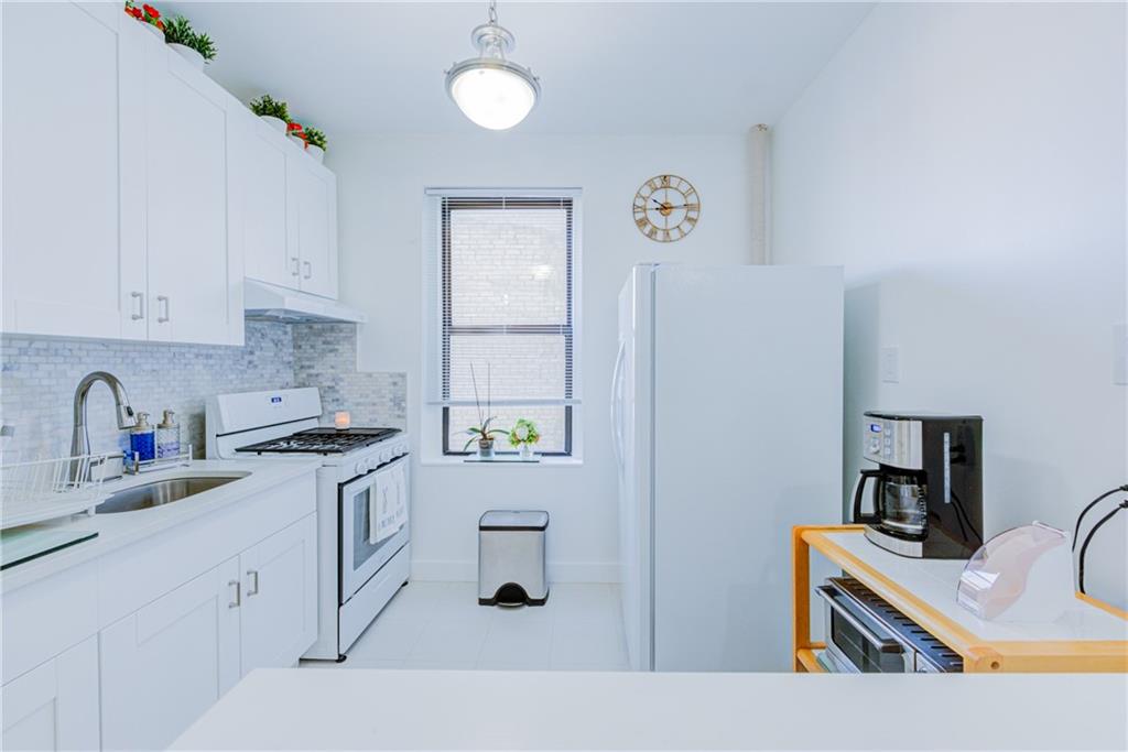255 79th Street, Unit E11 Brooklyn, NY 11209 - Photo 19 of 34 a kitchen with stainless steel appliances granite countertop a sink stove and cabinets